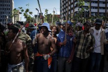 Protestors hold branches and sticks during a protest march against undocumented migrants organised by “March and March” in Johannesburg on April 29, 2026.