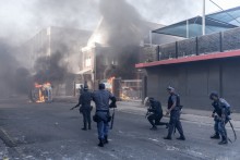 South African Police Service (SAPS) officers fire rubber bullets as clashes erupt between protesters and foreign nationals in Durban on October 8, 2026.