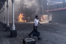 A man runs for cover after clashes erupt between protesters and foreign nationals in Durban on October 8, 2026.