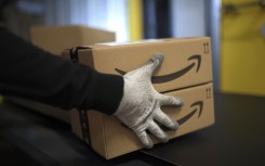 File: An employee carries a package at the distribution center of US online retail giant Amazon in Moenchengladbach, on December 17, 2019.
