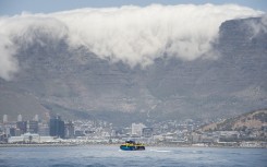 File: A ferry, with Table Mountain and part of the city in view, takes visitors back to the mainland after a tour of Robben Island.
