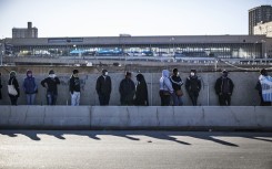 SASSA recipients waiting in a queue. AFP/Marco Longari