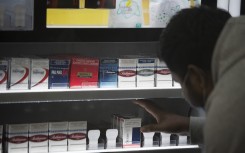 A shopkeeper packs well-known brands of cigarettes in his shop, as cigarettes are unbanned, in Athlone, Cape Town, on August 18, 2020 in Cape Town. 