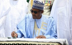 Nigerian President Muhammadu Buhari signs a register during a ceremony to mark the 59th anniversary of Nigeria's independence from England, on October 1, 2019 at the presidency in Abuja.