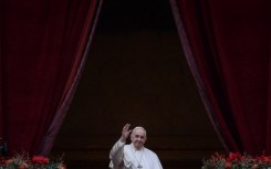 Pope Francis waves to the gathered faithful following his Christmas Urbi et Orbi blessing in St. Peter's Square at The Vatican on December 25, 2021 .