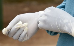 File: A health worker puts on medical gloves. PASCAL GUYOT / AFP