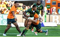 South Africa's Damian Willemse tries to ride an Australian tackle