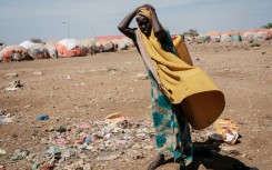 A woman carries a water container at a camp for internally displaced persons in Somalia, which has received insufficient rainfall since late 2020 