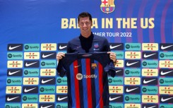 If the cap fits: Robert Lewandowski about to try on a Barcelona shirt after joining the club in July