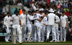 Early strike - England's Ollie Robinson (C) is congratulated by teammates after dismissing South Africa captain Dean Elgar (L) in the third Test at the Oval