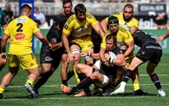 Lyon's South African number 8 Arno Botha (C) is challenged during the French Top 14 rugby union match against La Rochelle