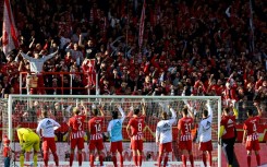 Union Berlin players celebrate with their fans after beating Wolfsburg to stay top of the Bundesliga 