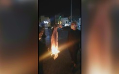 Protesters cheer as a woman burns her headscarf in Iran's southwestern city of Bushehr