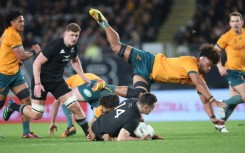 New Zealand's Will Jordan is tackled as Australia's Rob Valentini dives over the top during the rugby test match at Eden Park in Auckland
