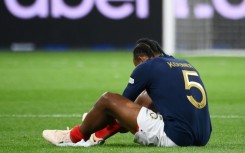Jules Kounde sits on the pitch after injuring his thigh  playing for France against Austria