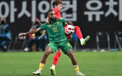 South Korea's Kim Jin-su (top) fights for the ball with Cameroon's Bryan Mbeumo in Seoul