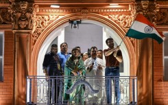 Former Indian cricket captain Sourav Ganguly, right, waves the flag of India during the inauguration of a replica balcony of the Lord's Cricket Ground in London 