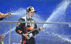 Sergio Perez celebrates with champagne on the podium after winning the Formula One Singapore Grand Prix