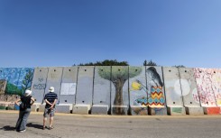 Israeli tourists seen near the northern border wall with Lebanon, close to the Israeli settlement of Shtula