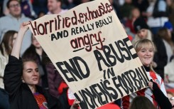 Supporters at Wembley hold up a banner protesting against abuse in women's football
