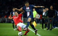 Paris Saint-Germain star Kylian Mbappe (r), trying to elude  Benfica's Gilberto Moraes Junior, was the focus of attention on and off the field