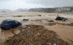 Cars are carried away by floods at the beach of the popular resort of Agia Pelagia, on the southern Greek island of Crete, following flash floods on October 15, 2022