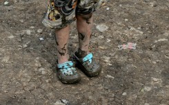 The shoes of a Venezuelan migrant girl are coated in mud after traveling through the Darien Jungle 