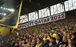 Dortmund fans in the club's famous 'yellow wall' hold up a banner reading "#Boycott Qatar 2022" 