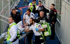 Israeli security forces and emergency personnel carry away a Palestinian man, shot after a stabbing attack in east Jerusalem