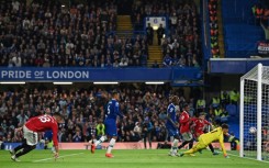 Manchester United's Casemiro (L) looks on as Kepa Arrizabalaga fails to keep the ball from crossing the line