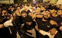 Men carry the body of the alleged Lion's Den leader from a hospital in Nablus after he was killed in a clash with Israeli soldiers, in the occupied West Bank on early October 25, 2022