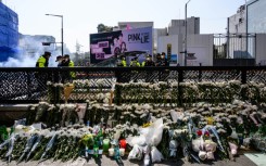 Flower tributes are seen at a makeshift memorial outside a subway station in Seoul's Itaewon district, two days after a deadly Halloween surge in the area