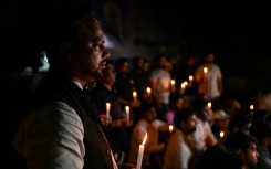 Members of India's Youth Congress take part in a candlelight vigil in New Delhi on Monday for victims of the bridge collapse