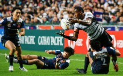 Fiji's Joseva Talacolo (top R) offloads the ball while tackled by Japan's Kazuma Nakagawa on the first day of the Hong Kong Sevens rugby tournament