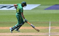 The Netherlands' Tom Cooper plays a shot over the boundary line for six runs watched by South Africa's wicketkeeper Quinton de Kock (L) during their men's Twenty20 World Cup match