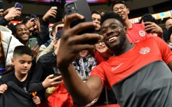 Man of the people: Davies takes a selfie with fans after a CONCACAF Nations League game in June