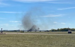 Smoke rises from the crash site after two planes collided mid-air during the Wings Over Dallas Airshow on November 12, 2022