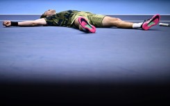 Andrey Rublev collpases after winning his first round-robin match against fellow Russian Daniil Medvedev at the ATP Finals in Turin