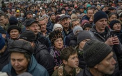Local residents wait at a food distribution center in Kherson 