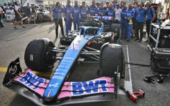 Fernando Alonso (front row, centre-R) poses for a group picture with his team ahead of his final race for Alpine at the Abu Dhabi Grand Prix