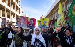 Syrian-Kurdish demonstrators in Qamishli raise pictures of people killed in Turkish strikes
