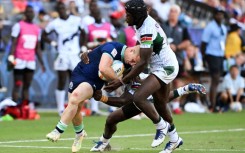 Kenya's Willy Ambaka (C) and Vincent Onyala (R) tackle Scotland's Reiss Cullen in the World Rugby Sevens Series event in Carson, California on August 27, 2022.