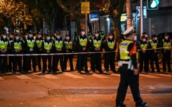 Police officers block Wulumuqi street, named for Urumqi in Mandarin, in Shanghai, where protests have taken place against China's zero-Covid policy 