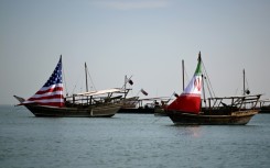 Traditional Qatari dhow boats fly the US and Iranian flags off the coast of Doha