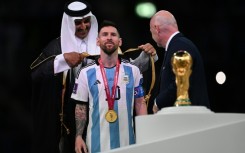 Honour: Qatar's Emir Sheikh Tamim bin Hamad al-Thani presents Lionel Messi with a traditional cloak after winning the World Cup