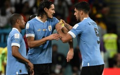 Luis Suarez (right) passes on the captain's armband to substitute Edinson Cavani at the World Cup