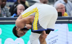 Golden State's Stephen Curry grimaces after suffering a left shoulder injury in the third quarter of the Warriors' 125-119 loss at Indiana 
