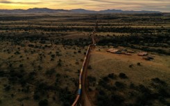 From the air, the makeshift wall of shipping containers along the US-Mexico border in Arizona resembles an enormous stationary freight train
