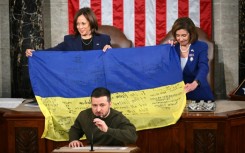 House Speaker Nancy Pelosi, left, and Vice President Kamala Harris hold a Ukrainian battle flag donated to Congress by Zelensky, front