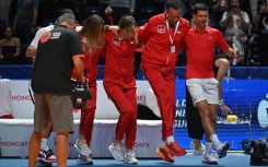 In perfect step: Novak Djokovic (right) celebrates with his teammates after victory in Dubai on Friday